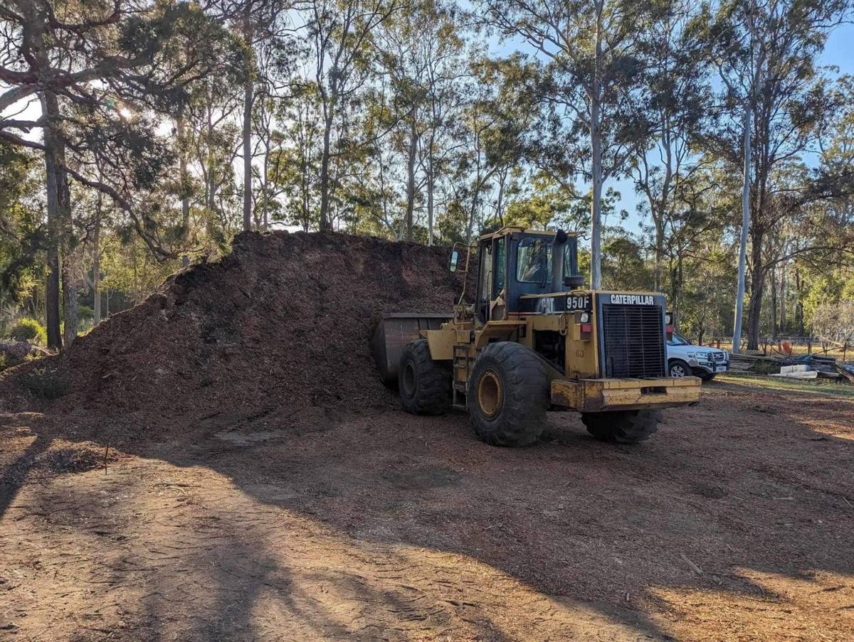 Loader stacking a big mulch pile on a cleared block