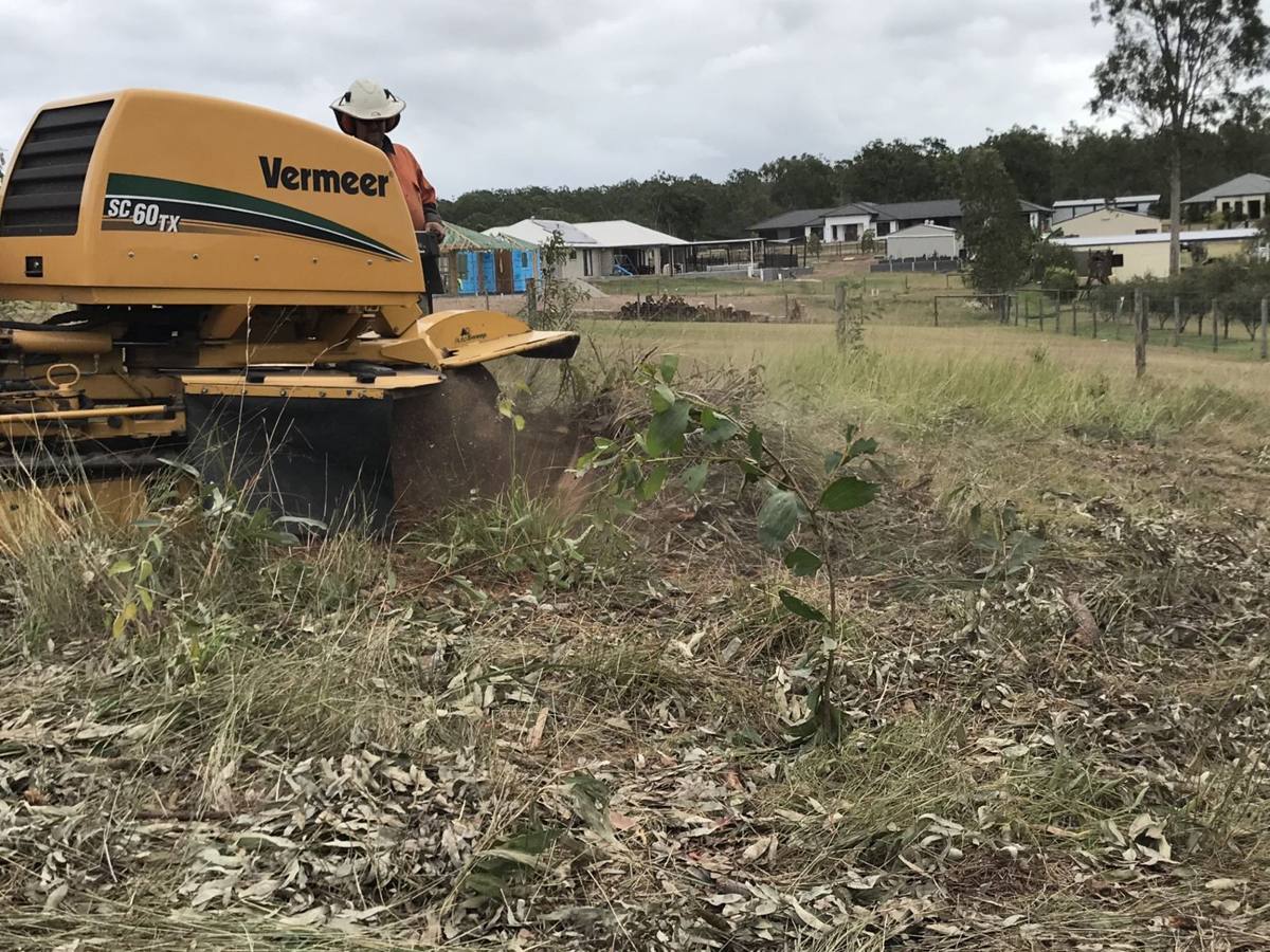 Vermeer SC60TX stump grinder grinding a large stump on an acreage lawn